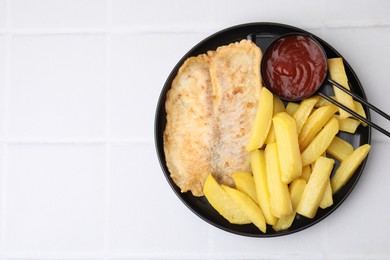 Photo of Delicious fish and chips with ketchup on white tiled table, top view