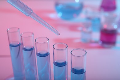 Photo of Dripping reagent into test tube with blue liquid, closeup. Laboratory analysis