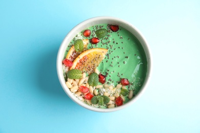 Photo of Bowl of spirulina smoothie on color background, top view