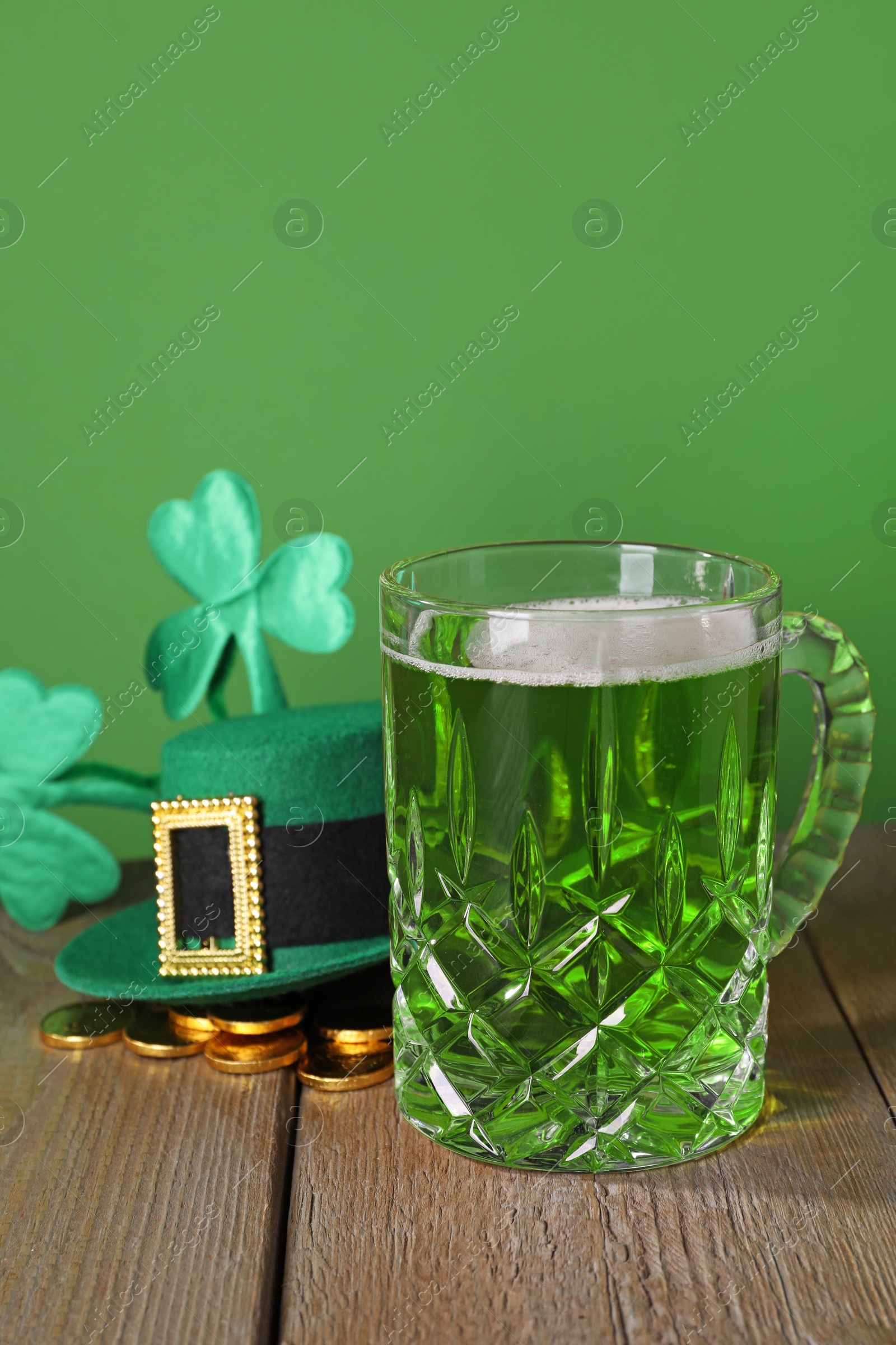 Photo of St. Patrick's day party. Green beer, leprechaun hat, gold and decorative clover leaves on wooden table