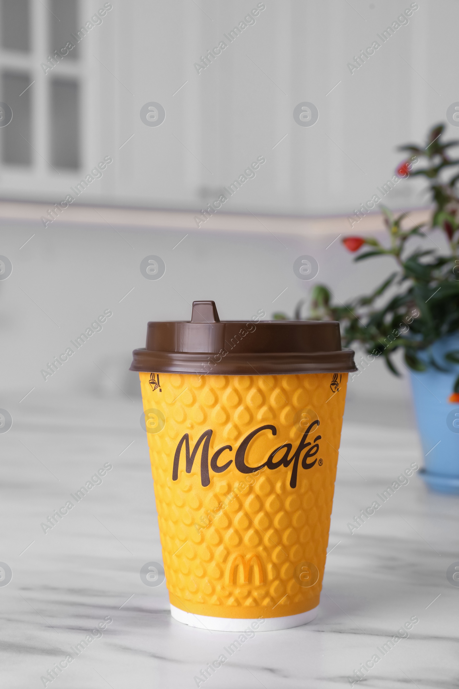 Photo of MYKOLAIV, UKRAINE - AUGUST 12, 2021: Hot McDonald's drink on marble table in kitchen