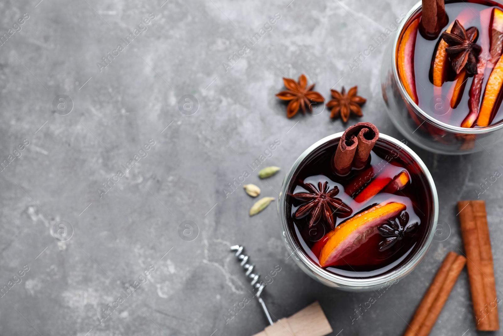 Photo of Flat lay composition with aromatic mulled wine on grey table. Space for text