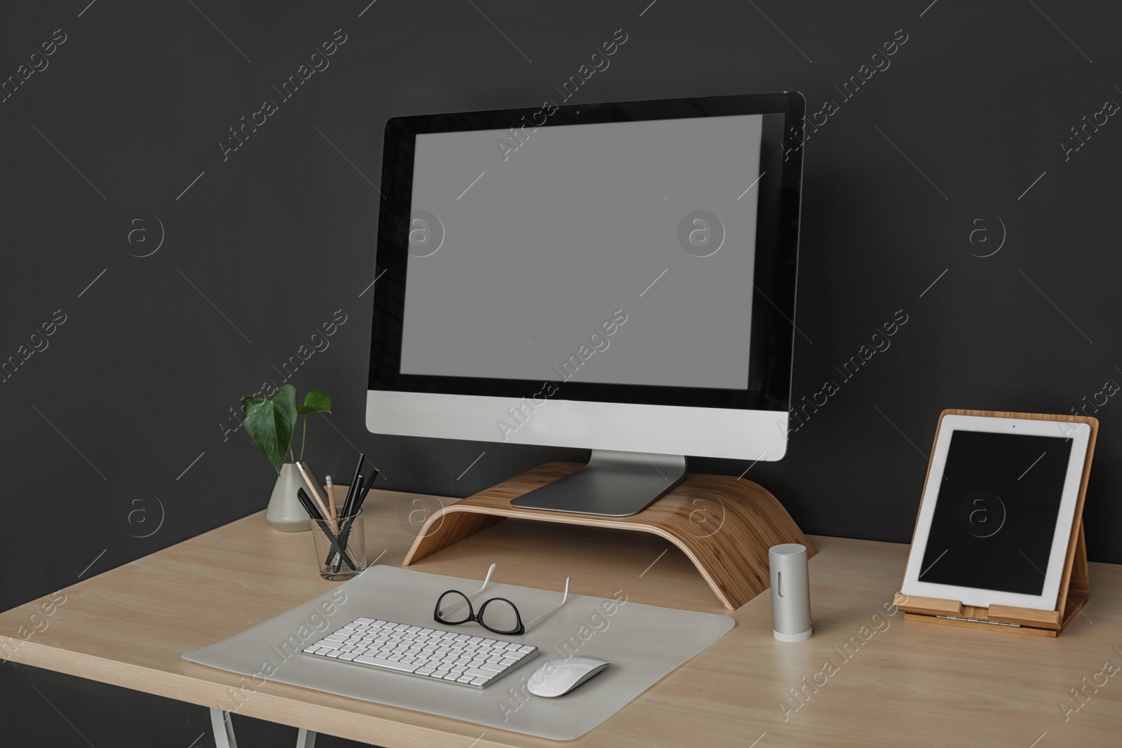 Photo of Modern workplace interior with computer on table. Space for text