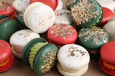 Photo of Beautifully decorated Christmas macarons on brown background, closeup