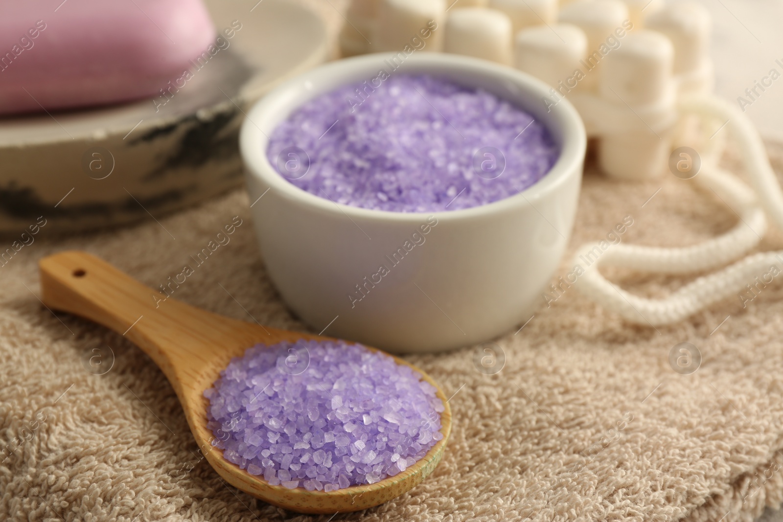 Photo of Purple sea salt on brown terry towel, closeup