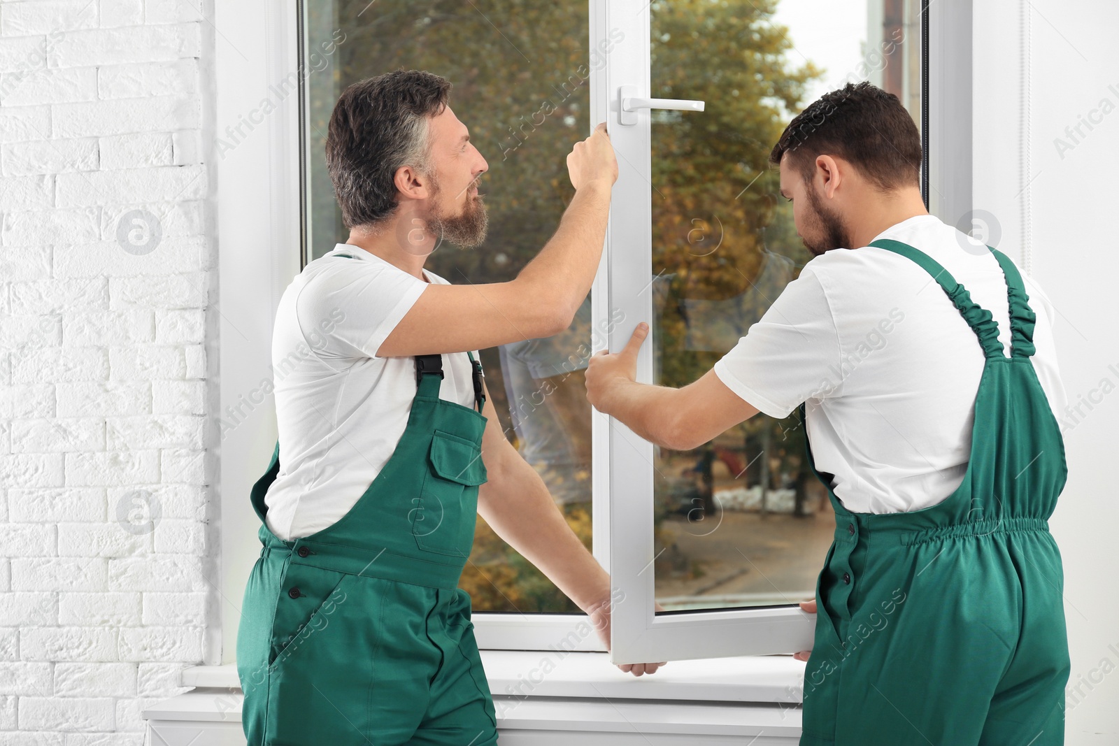 Photo of Construction workers installing new window in house