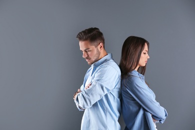 Photo of Upset young couple on grey background. Relationship problems