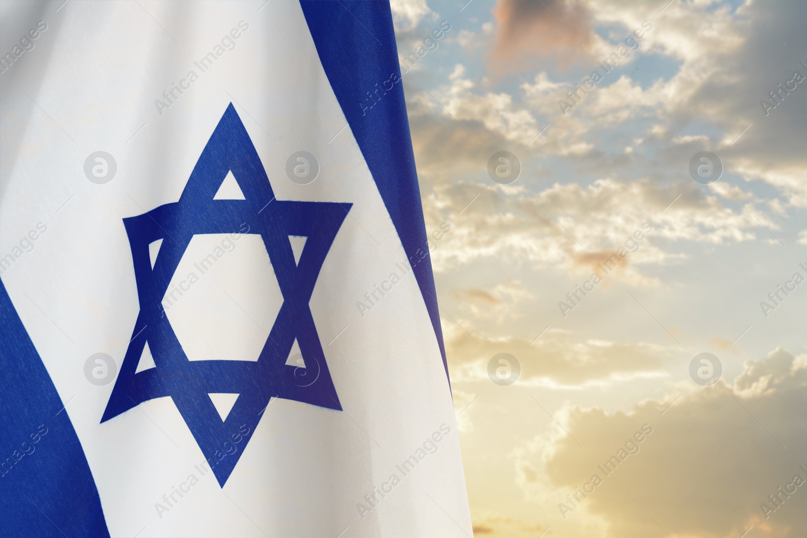 Image of National flag of Israel against blue sky with clouds