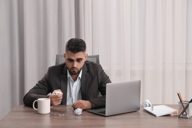 Photo of Sad businessman sitting at table in office