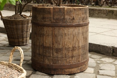 Photo of Traditional wooden barrel and wicker baskets outdoors