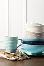 Photo of Beautiful ceramic dishware, cup and cutlery on wooden table