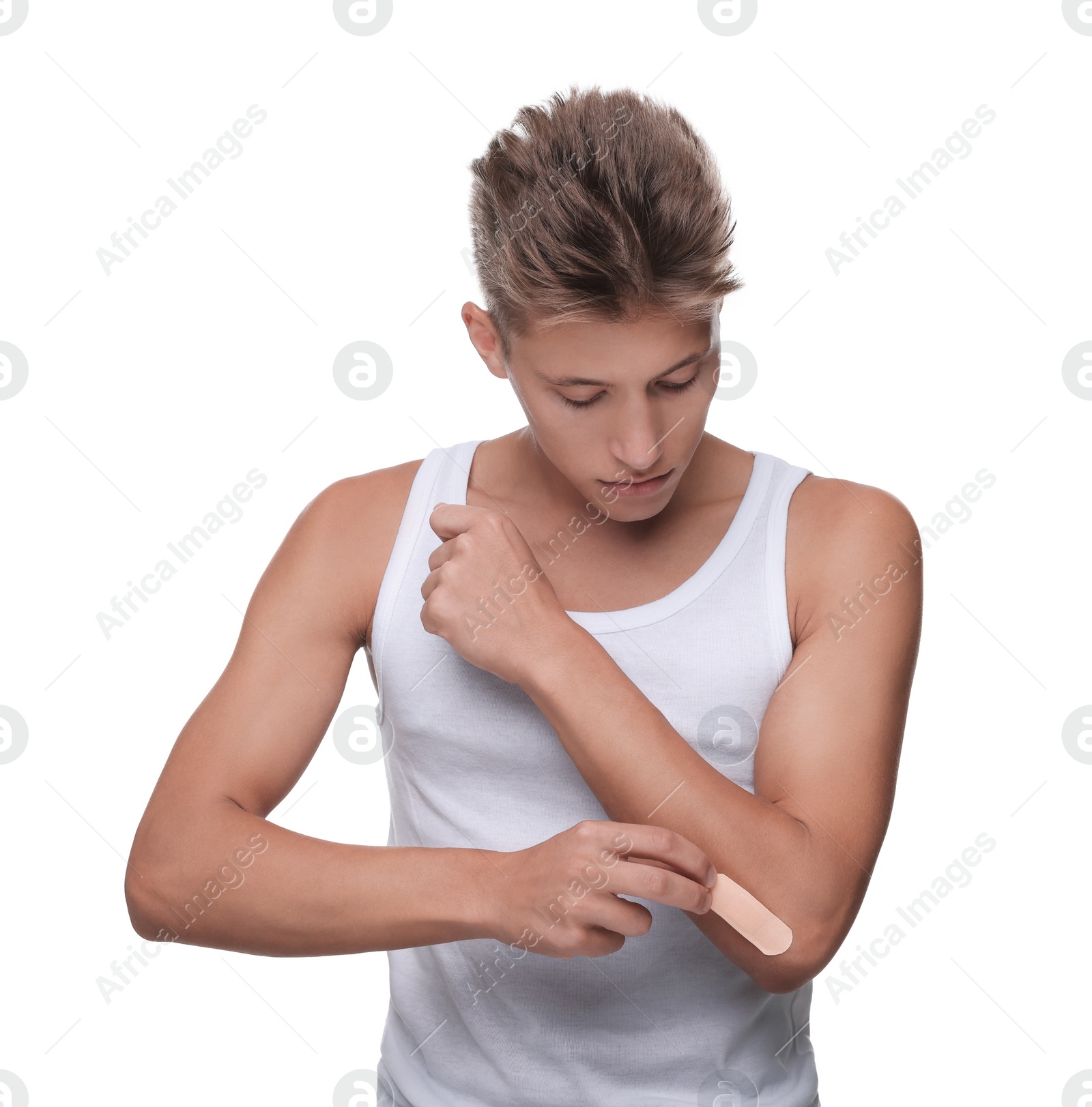 Photo of Handsome man putting sticking plaster onto elbow on white background