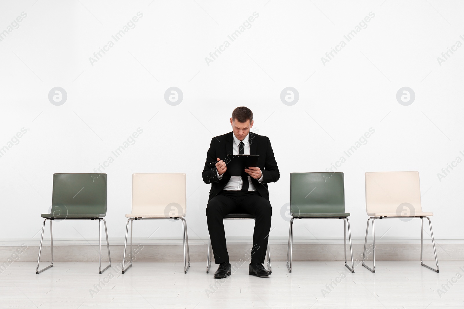 Photo of Man with clipboard waiting for job interview in office hall