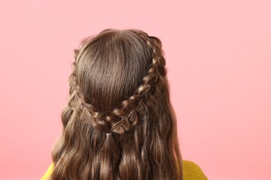 Photo of Little girl with braided hair on pink background, back view