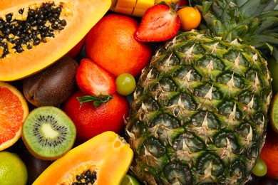 Photo of Many different delicious exotic fruits as background, top view
