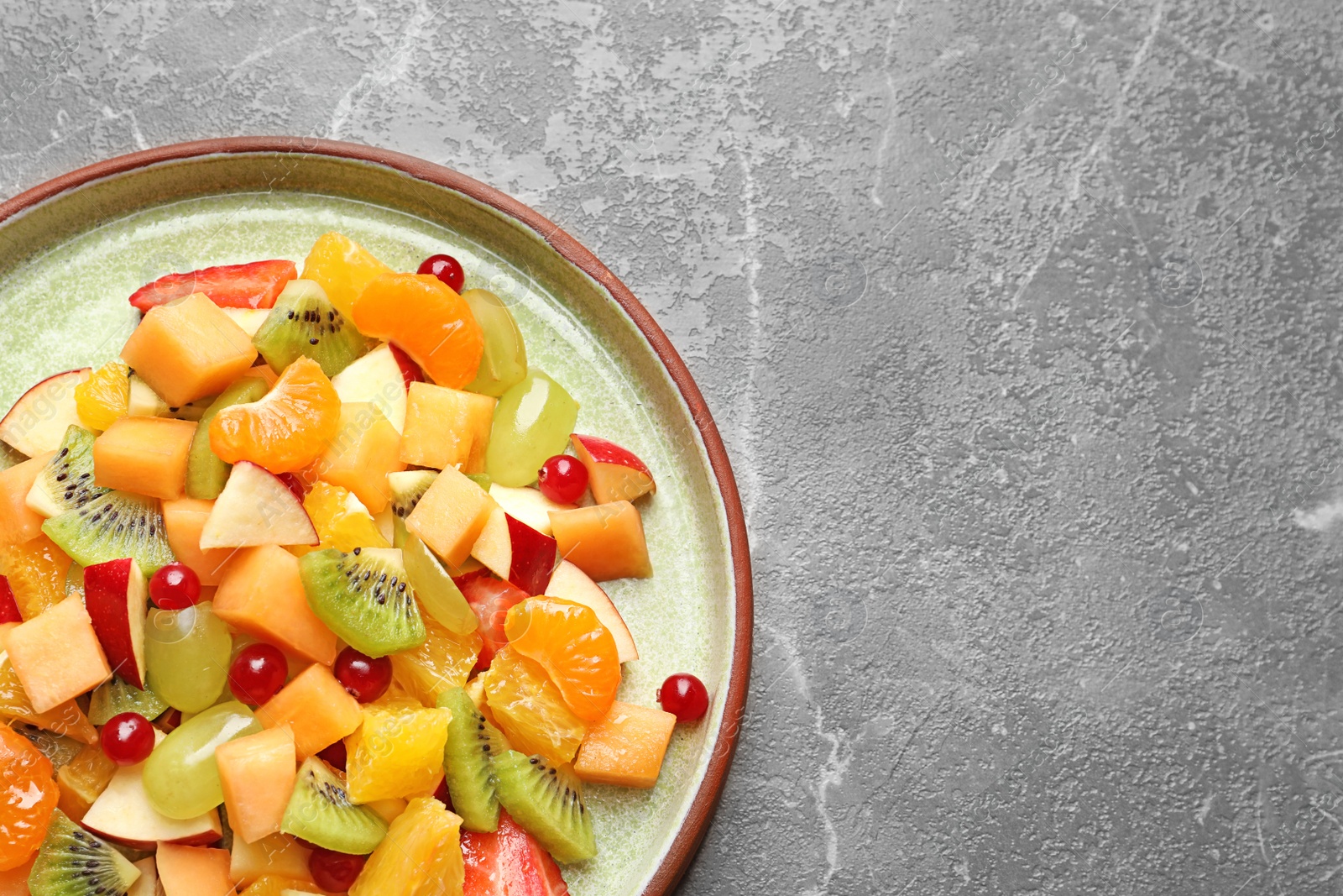 Photo of Plate with fresh cut fruits on table, top view