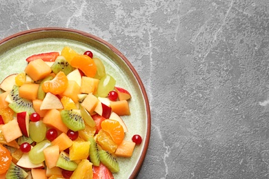 Photo of Plate with fresh cut fruits on table, top view