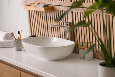 Photo of Stylish vessel sink near wooden wall in modern bathroom