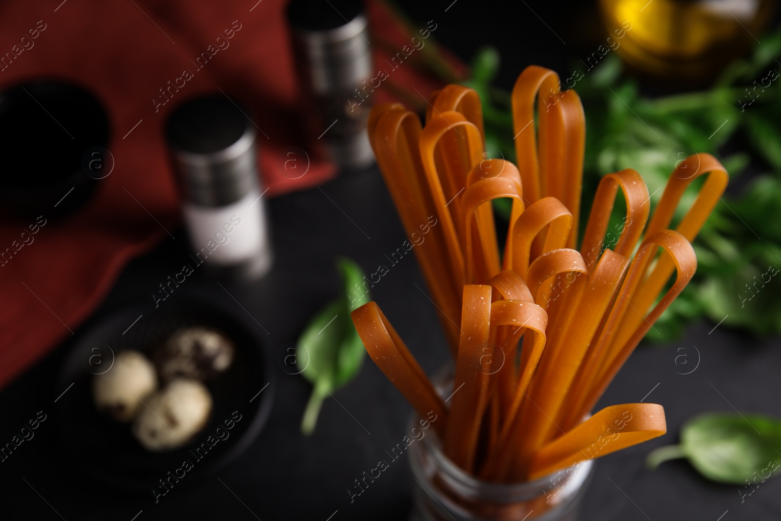 Photo of Uncooked buckwheat noodles on black table, closeup