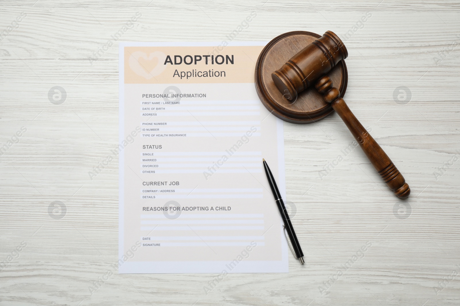 Photo of Adoption application, gavel and pen on white wooden table, flat lay
