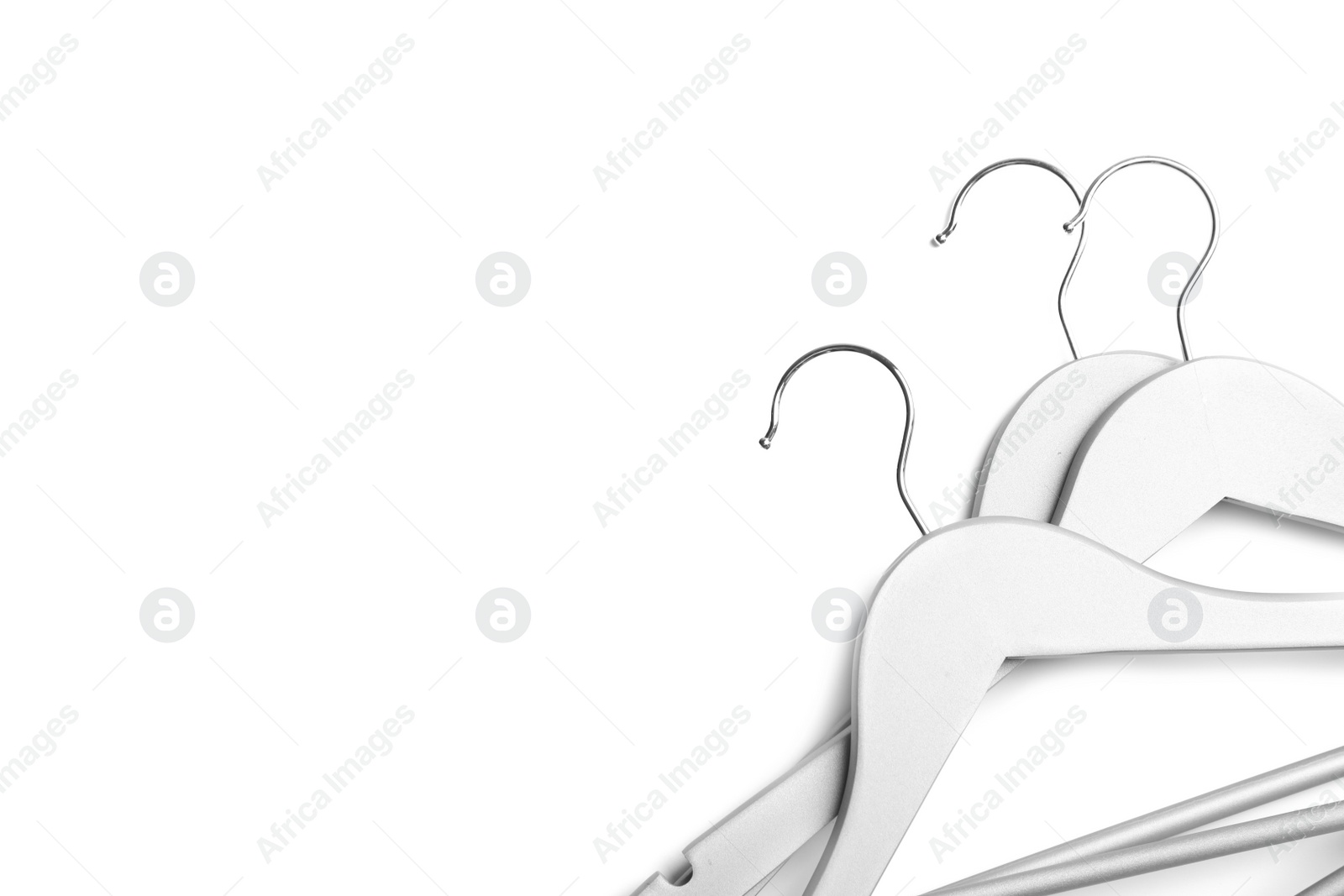 Photo of Empty clothes hangers on white background, top view