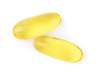 Photo of Yellow vitamin capsules isolated on white, top view