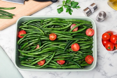 Photo of Dish with tasty green beans and tomatoes on table, top view