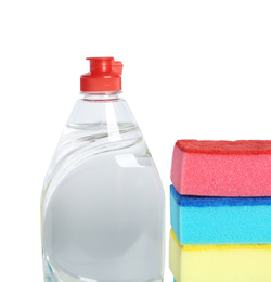 Photo of Bottle of detergent and sponges on white background