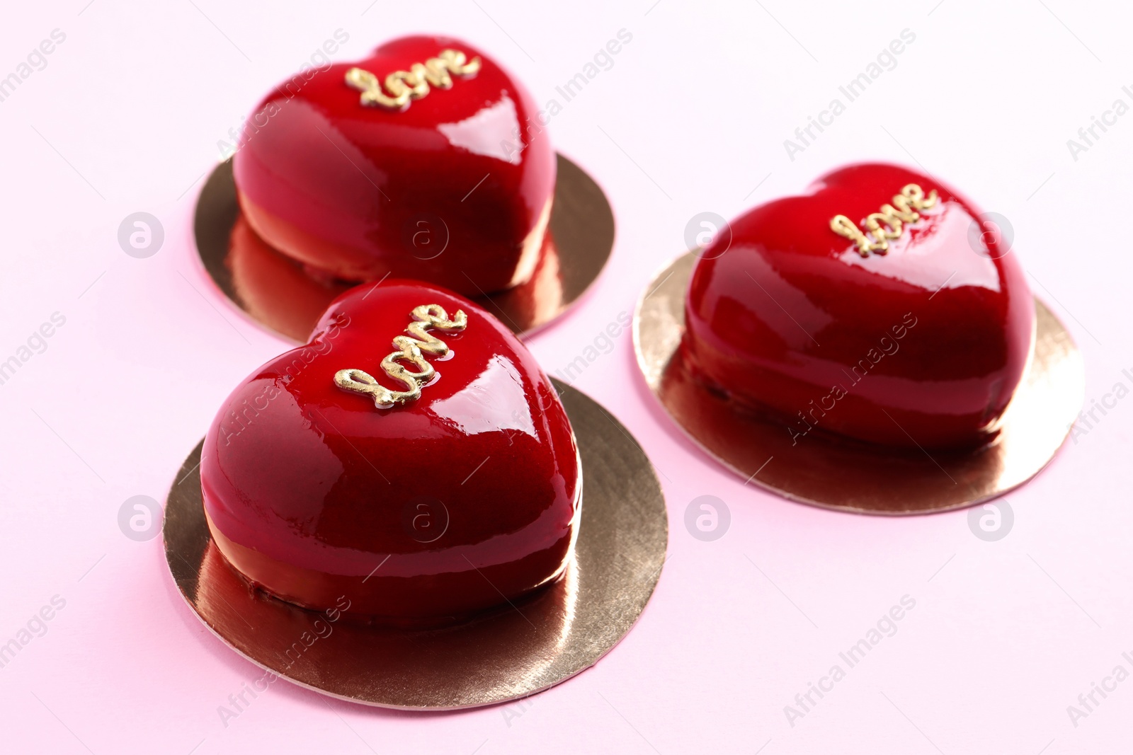 Photo of St. Valentine's Day. Delicious heart shaped cakes on light pink background, closeup