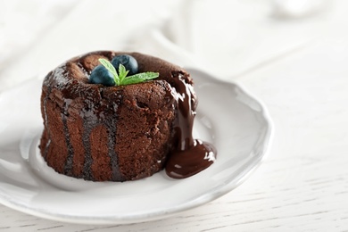 Plate of delicious fresh fondant with hot chocolate and blueberries on table. Lava cake recipe