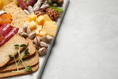 Photo of Different tasty appetizers on light marble table, closeup. Space for text