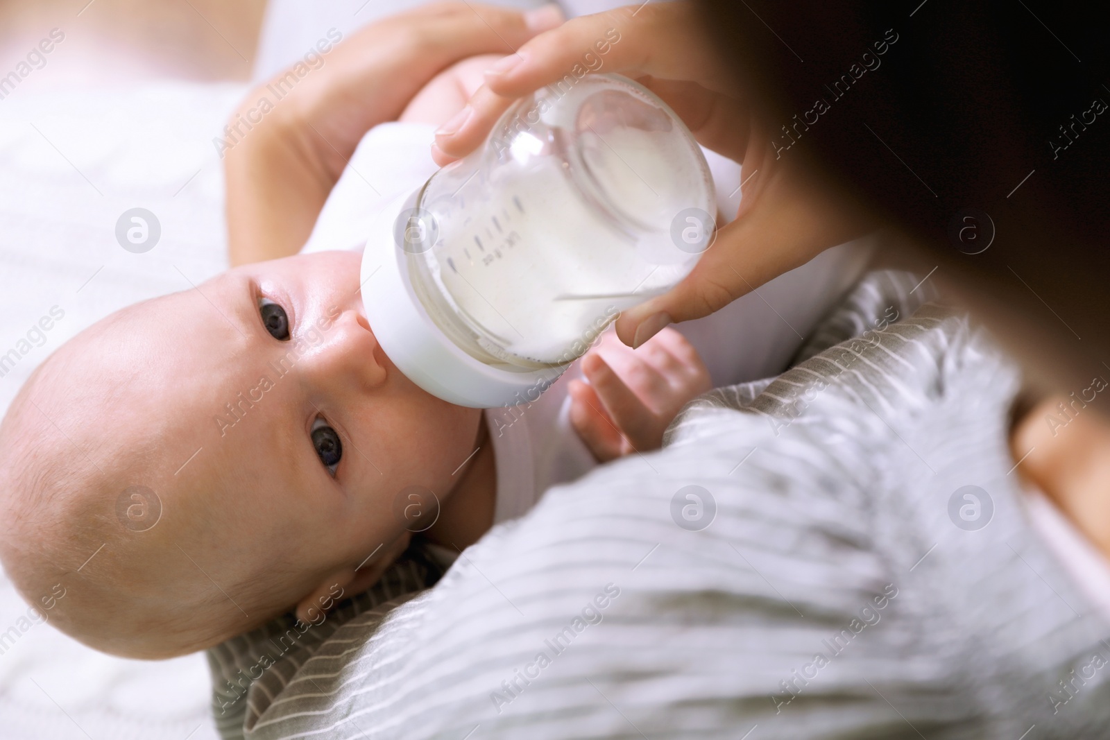 Photo of Mother feeding her little baby from bottle, closeup