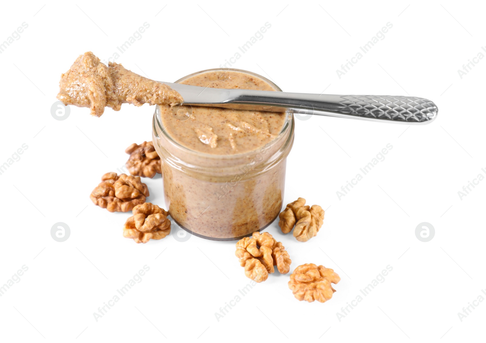 Photo of Delicious nut butter in jar, knife and walnuts isolated on white