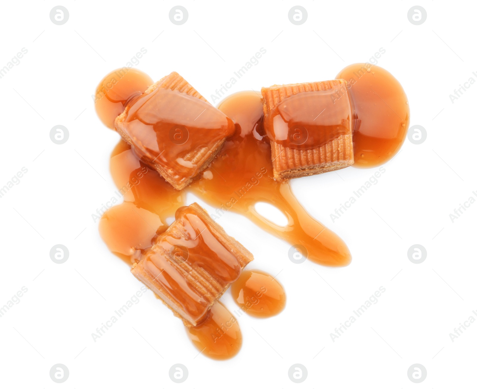 Photo of Delicious candies with caramel sauce on white background