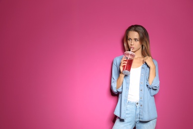 Portrait of beautiful woman with tasty drink on color background