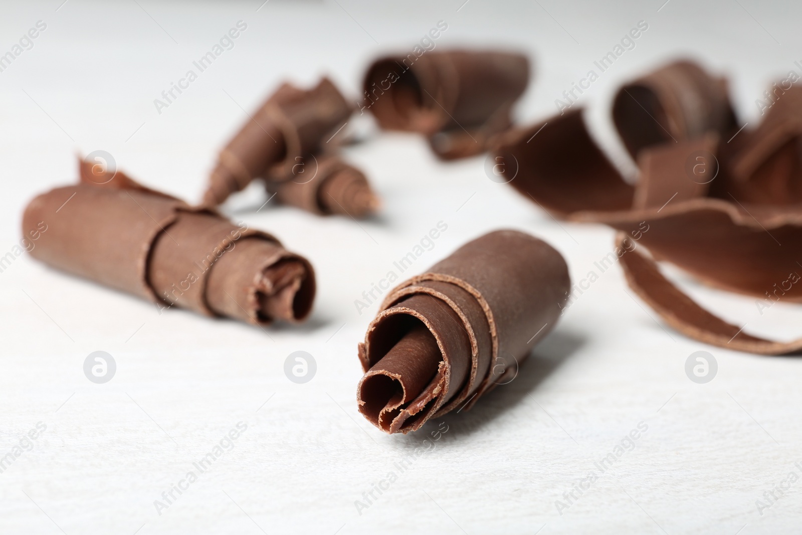 Photo of Chocolate curls for decor on table, closeup