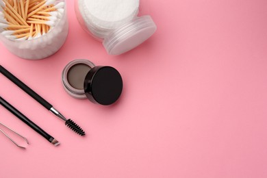Photo of Eyebrow pomade with henna effect and professional tools on pink background, flat lay. Space for text