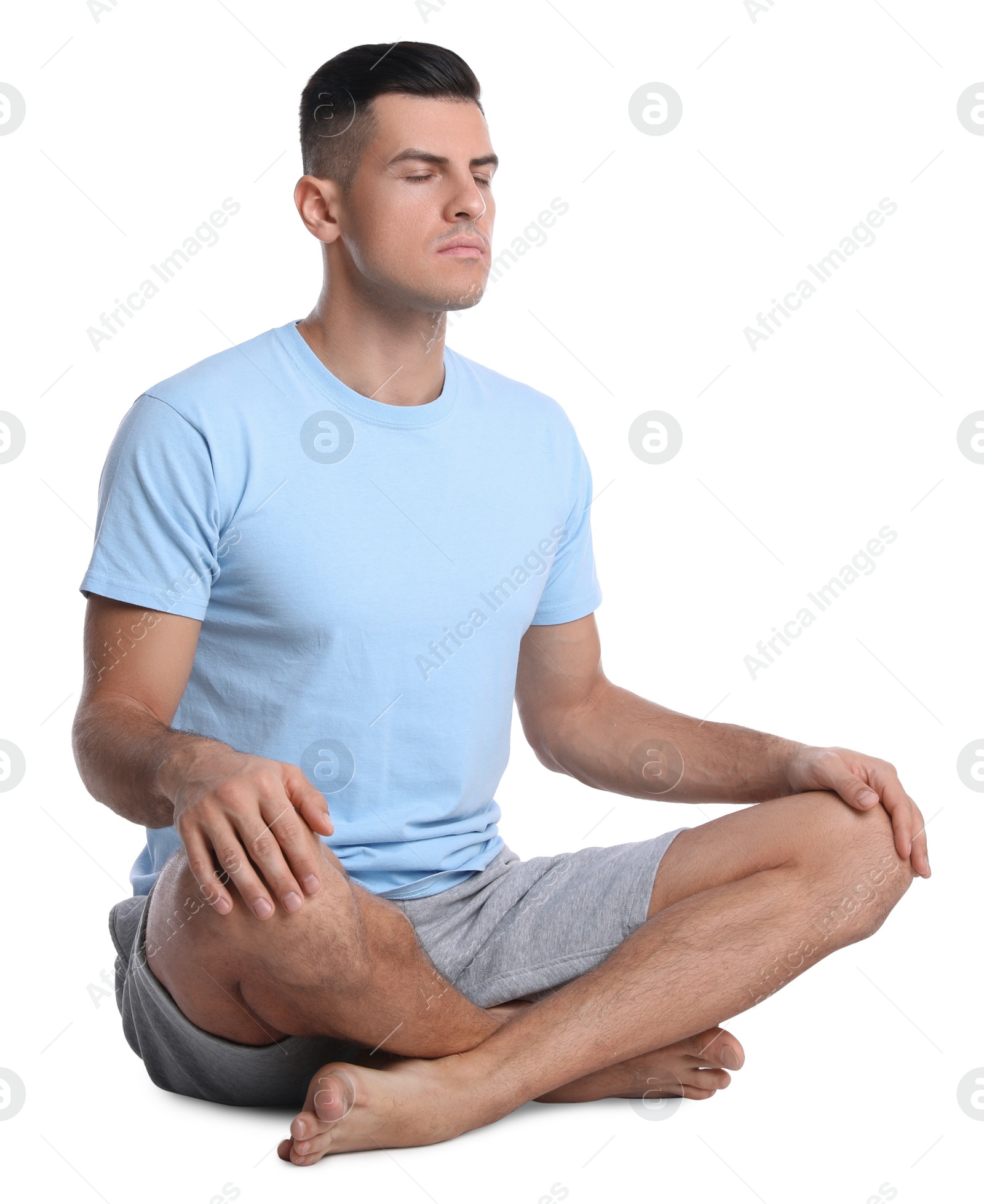 Photo of Handsome man meditating on white background. Harmony and zen