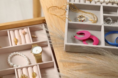 Photo of Jewelry boxes with many different accessories on wooden table, closeup