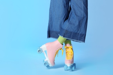 Photo of Woman with vintage roller skates on color background, closeup. Space for text