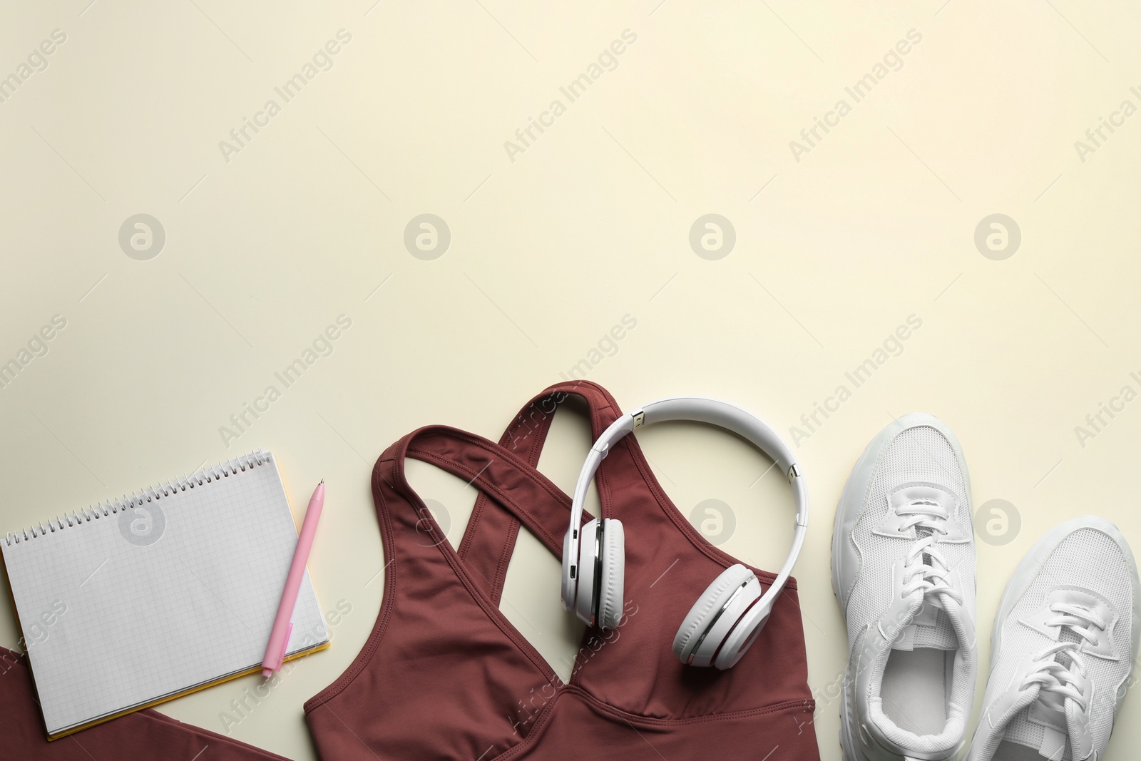 Photo of Flat lay composition with sportswear and notebook on light background, space for text. Gym workout plan