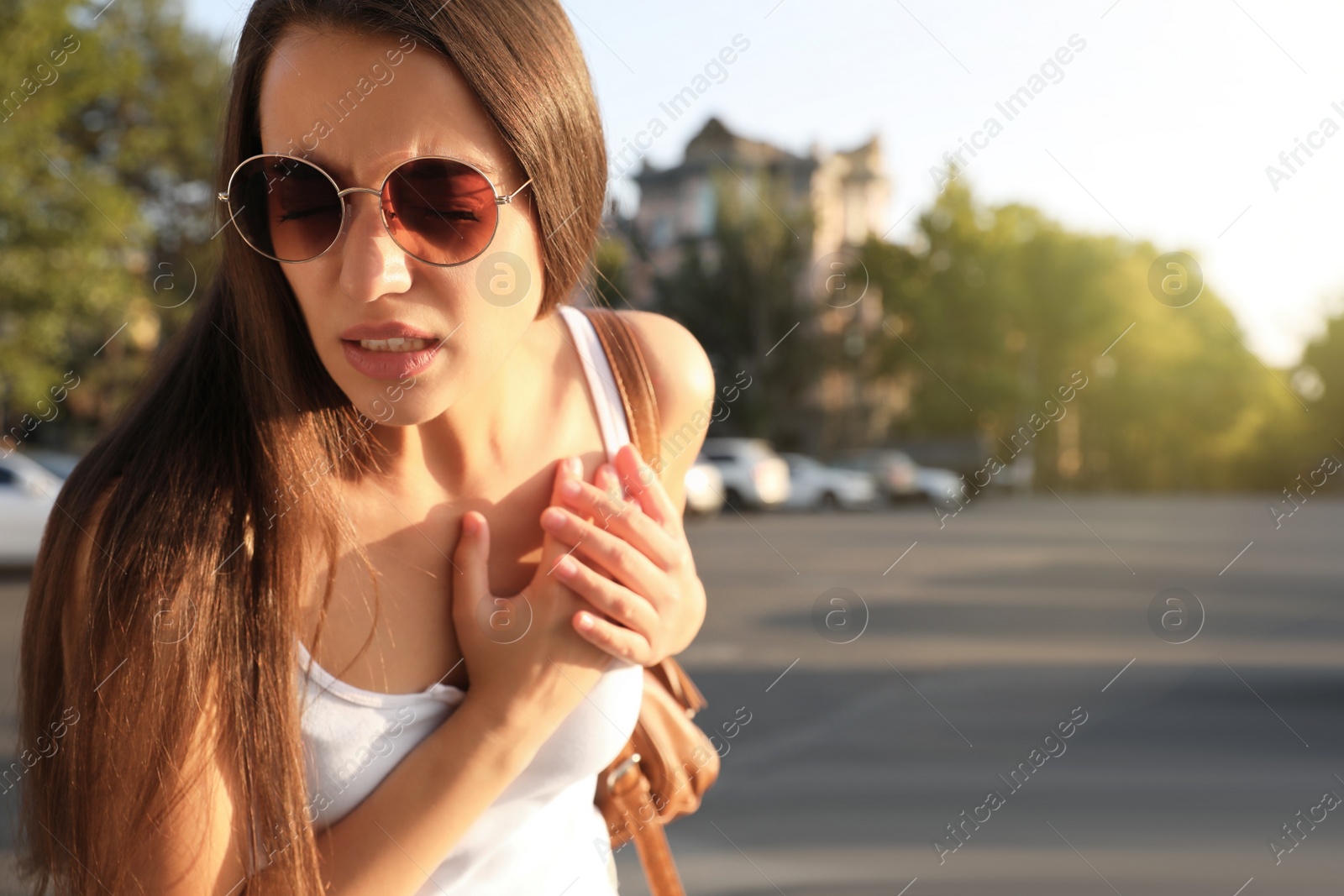 Photo of Young woman having heart attack on city street