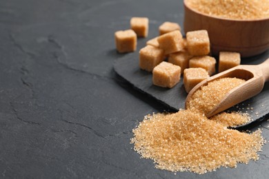 Photo of Brown sugar on black table, closeup. Space for text
