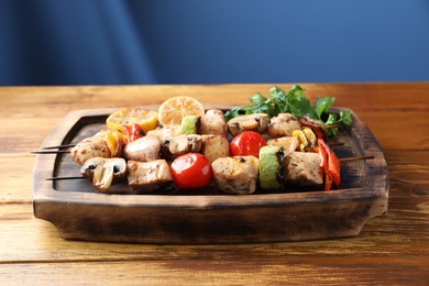 Photo of Delicious shish kebabs with grilled vegetables served on wooden table