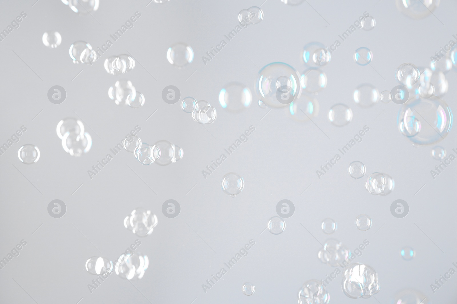 Photo of Beautiful transparent soap bubbles on light grey background