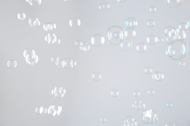 Photo of Beautiful transparent soap bubbles on light grey background