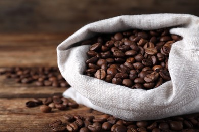 Photo of Bag of roasted coffee beans on wooden table, closeup