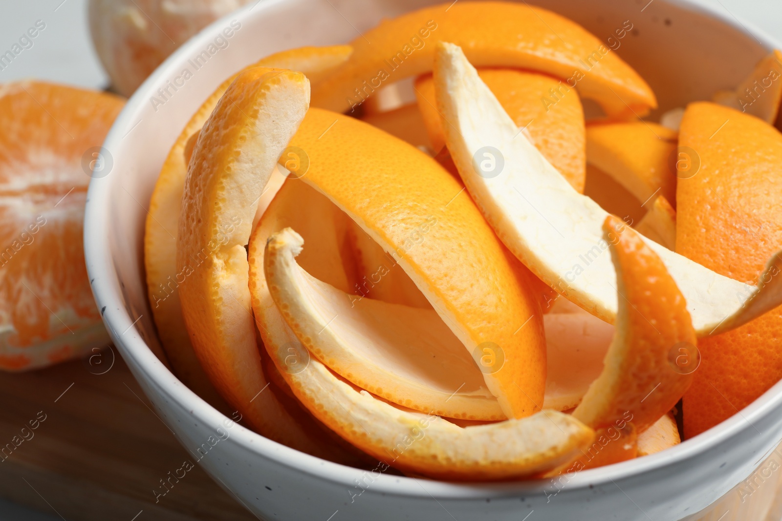 Photo of Orange zest preparing for drying and fresh fruits on wooden table, closeup