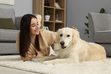 Happy woman with cute Labrador Retriever dog on floor at home. Adorable pet