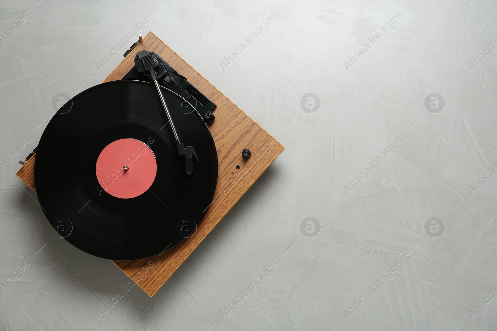 Photo of Turntable with vinyl record on light background, top view. Space for text